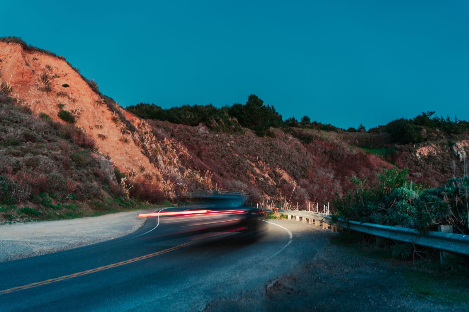 A car on a long straight highway at dusk, the kind of drive between Hamilton and London