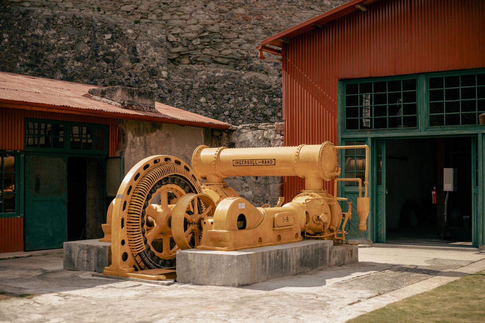 Polished steam engine machinery inside an industrial heritage museum, like the beam engines at Hamilton's Museum of Steam & Technology