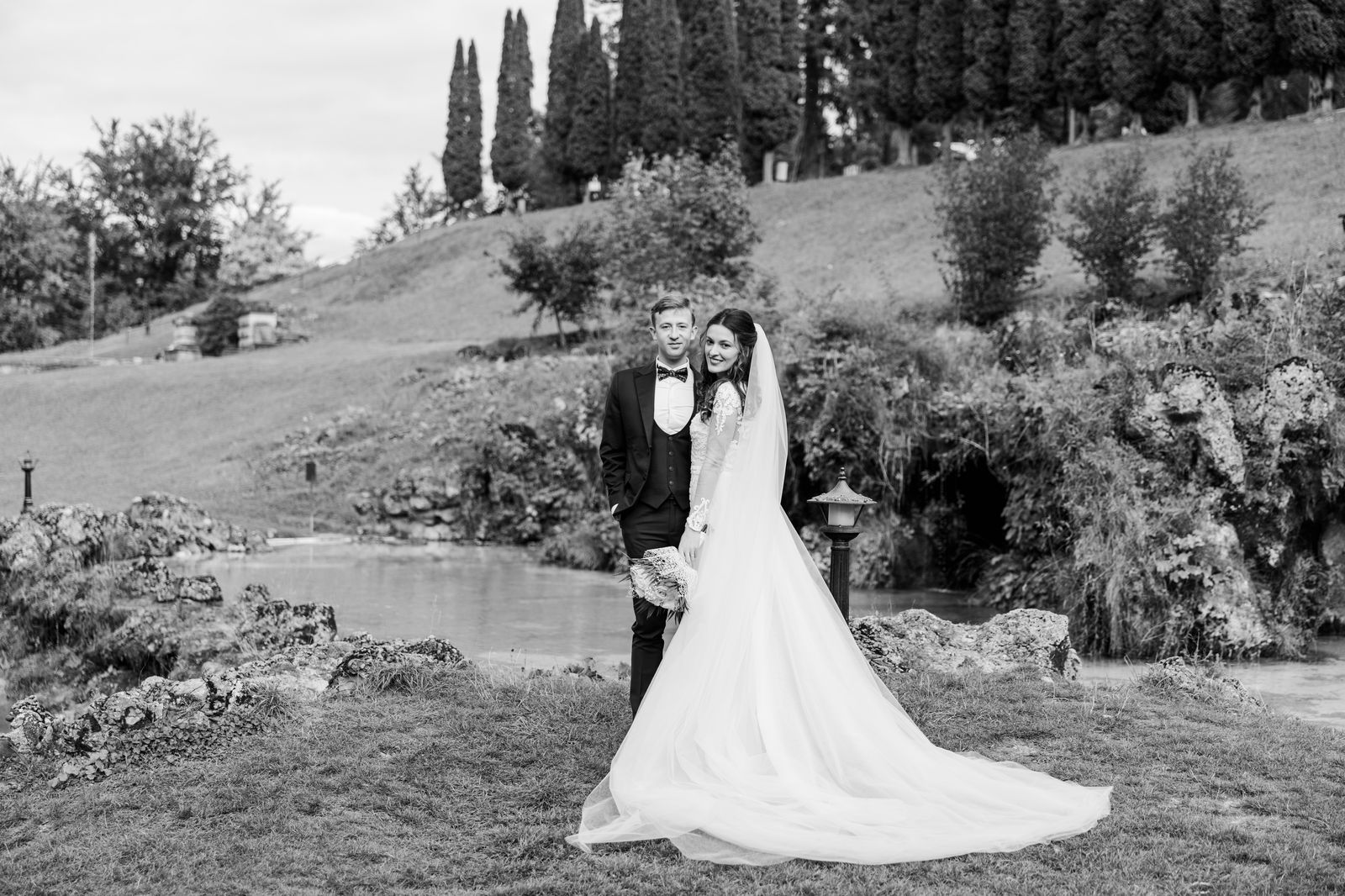 A wedding couple posing for portraits in a formal garden, a common chauffeured stop at Royal Botanical Gardens