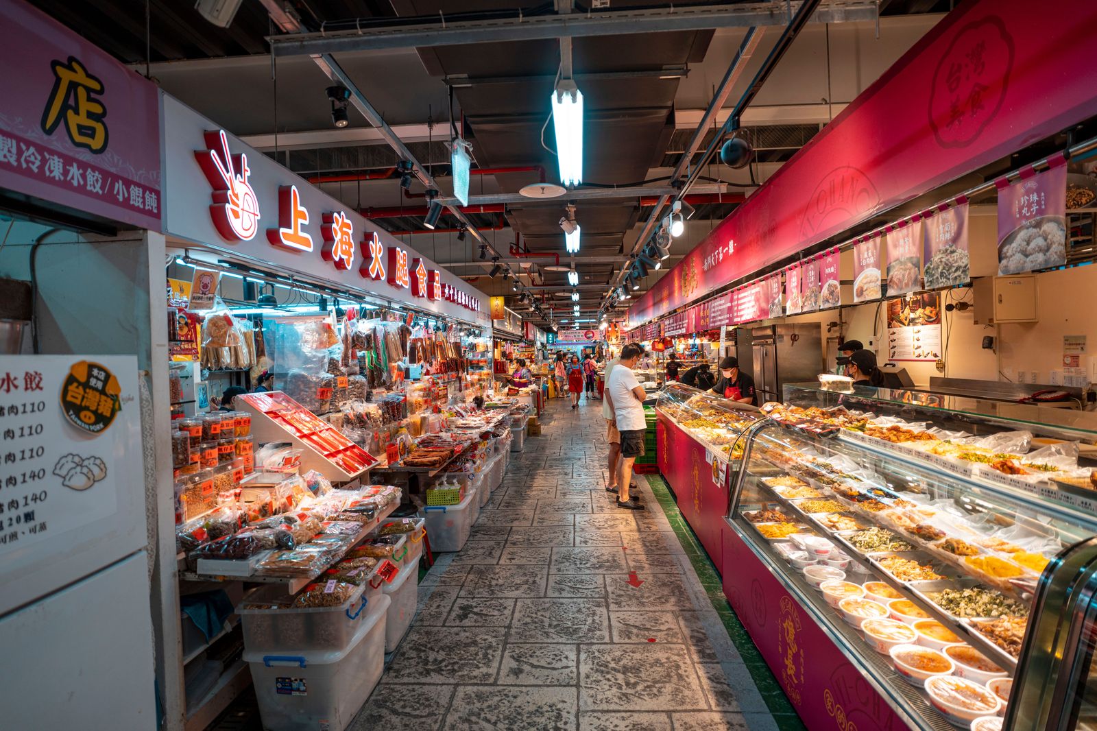 Food stalls and shoppers inside a busy indoor market hall