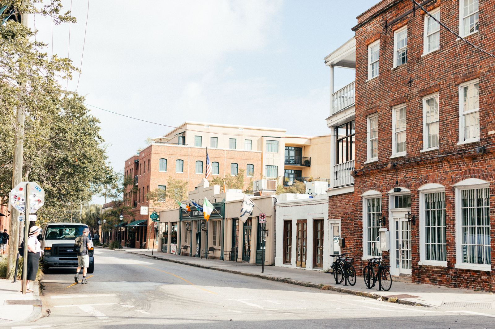 Pedestrians on a brick-paved street between restored industrial buildings