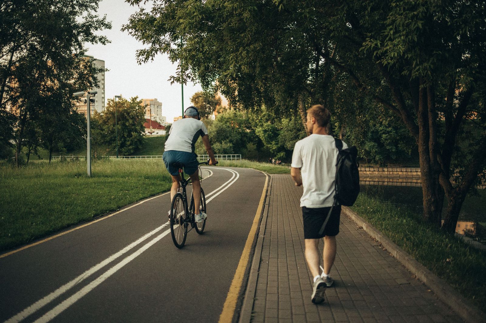 Walkers and cyclists on a wide lakeside trail, similar to the Hamilton Waterfront Trail between Bayfront Park and Pier 4
