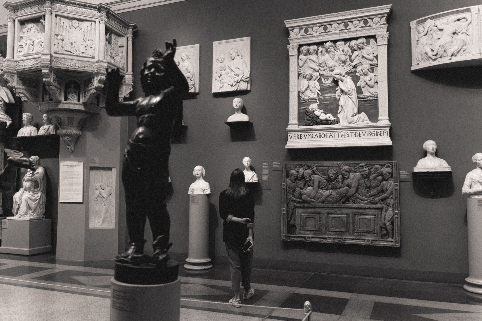 Visitors walking among sculptures in a bright gallery space
