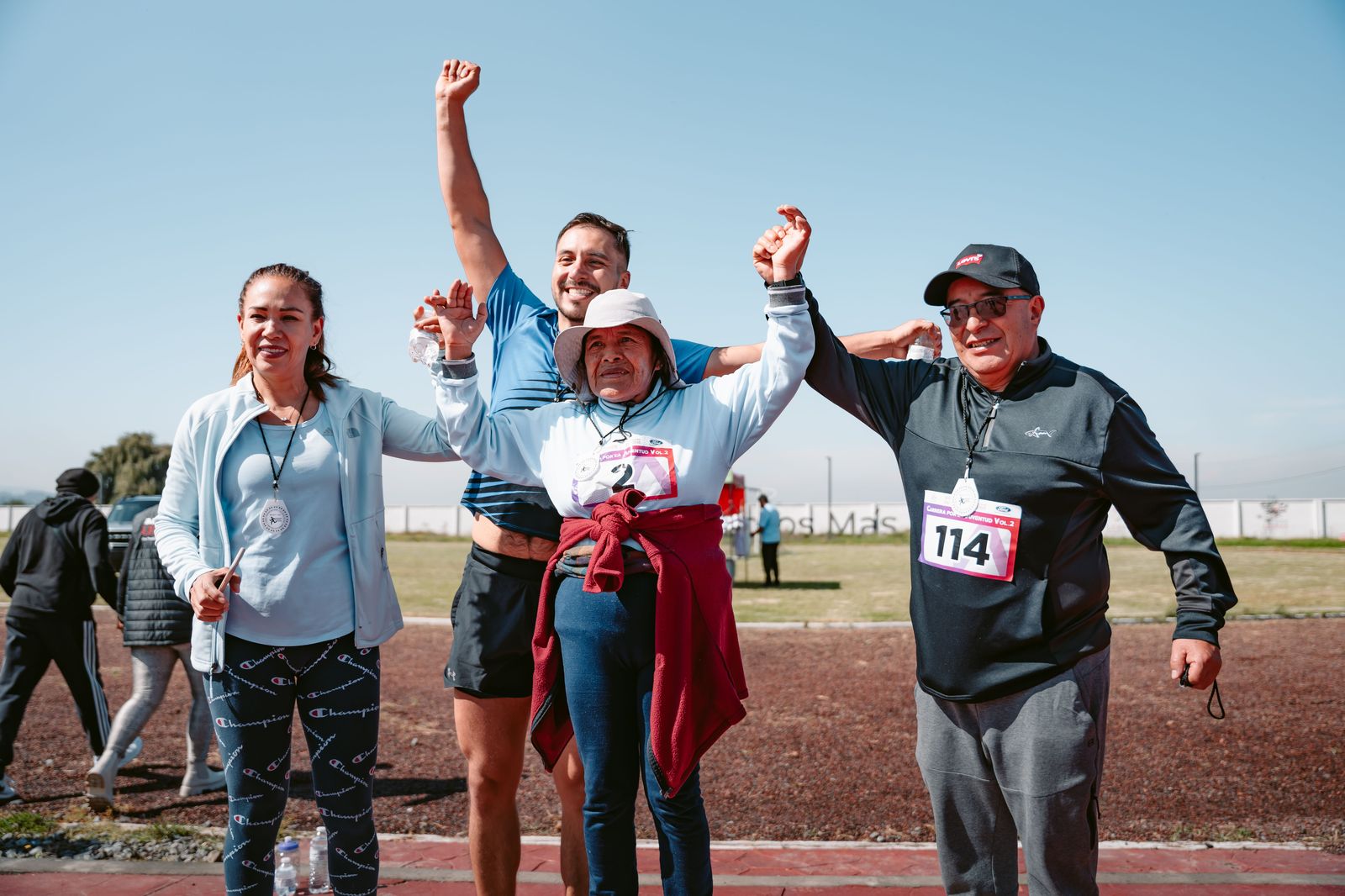 Running club posing together with medals after a spring road race