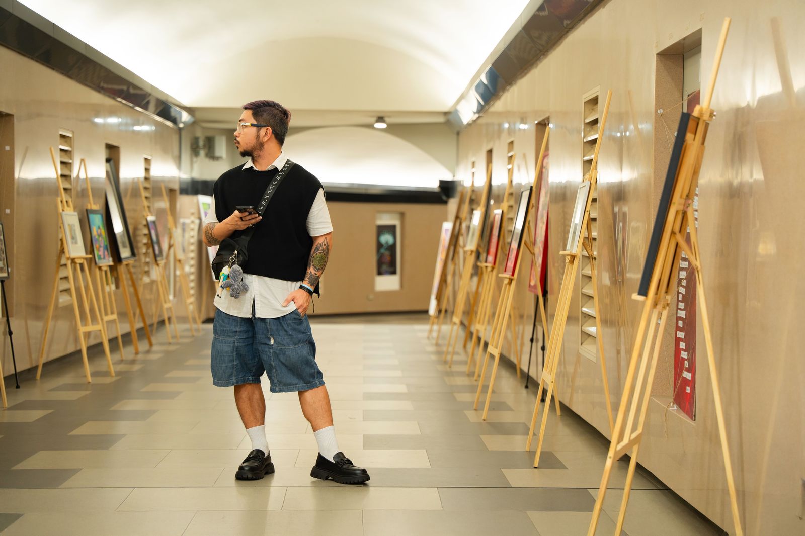 Visitors looking at paintings inside a small gallery during a Hamilton Art Crawl evening