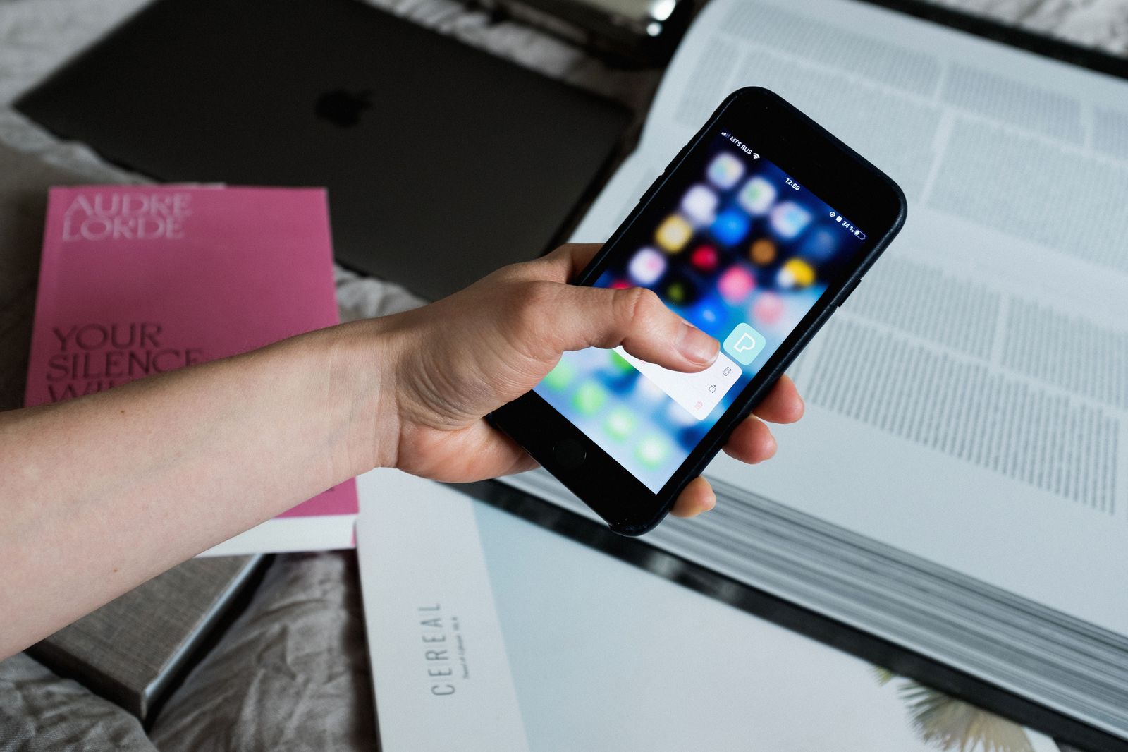A hand holding a phone while making an online booking