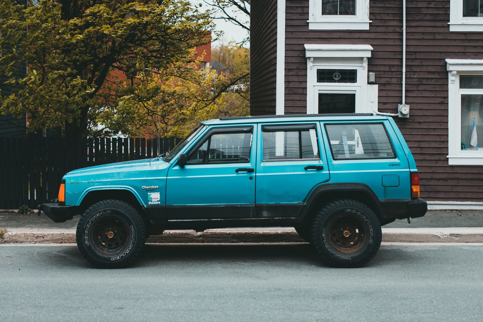 A black executive SUV waiting on a Hamilton side street while a group visits a taproom
