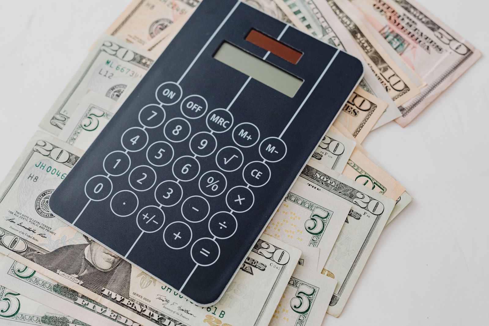 A calculator, passports and a travel budget notebook on a table