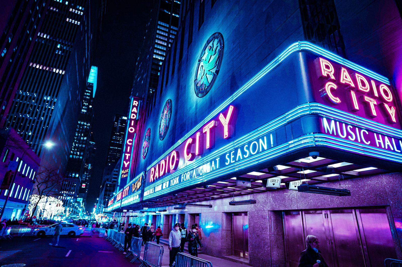 A theatre marquee lit up on a city street at night
