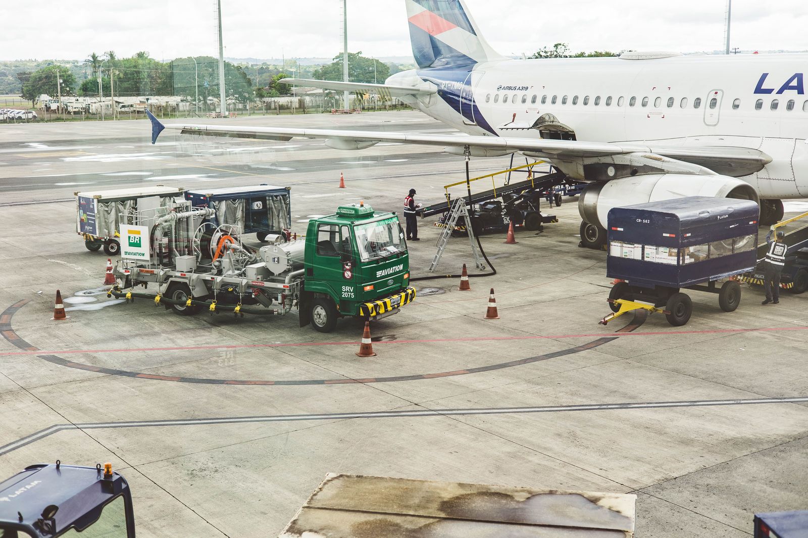 A car stopping at an airport departures curb to drop off travellers