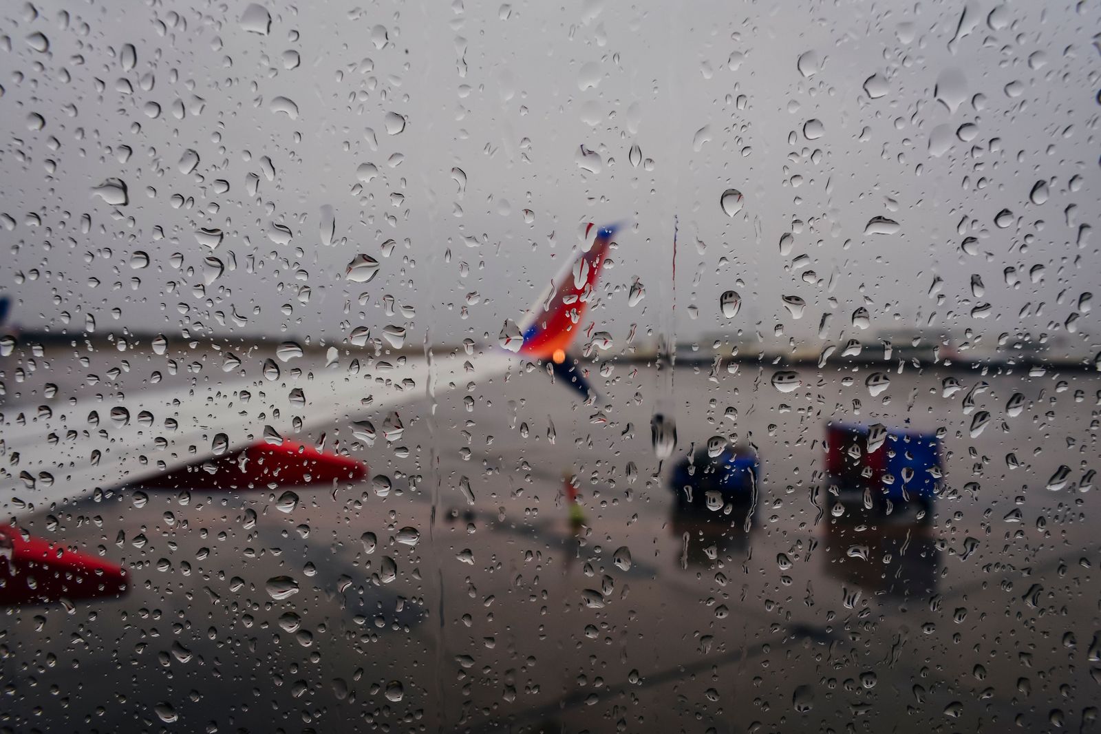 A toddler watching aircraft through an airport terminal window before a family flight