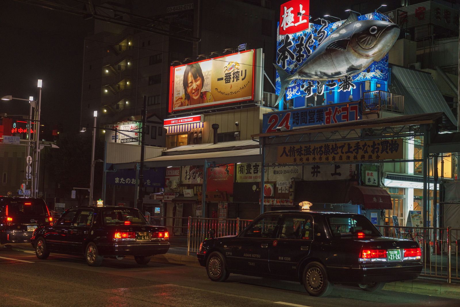 A taxi on a city street at night, one of the services people compare with a booked chauffeur