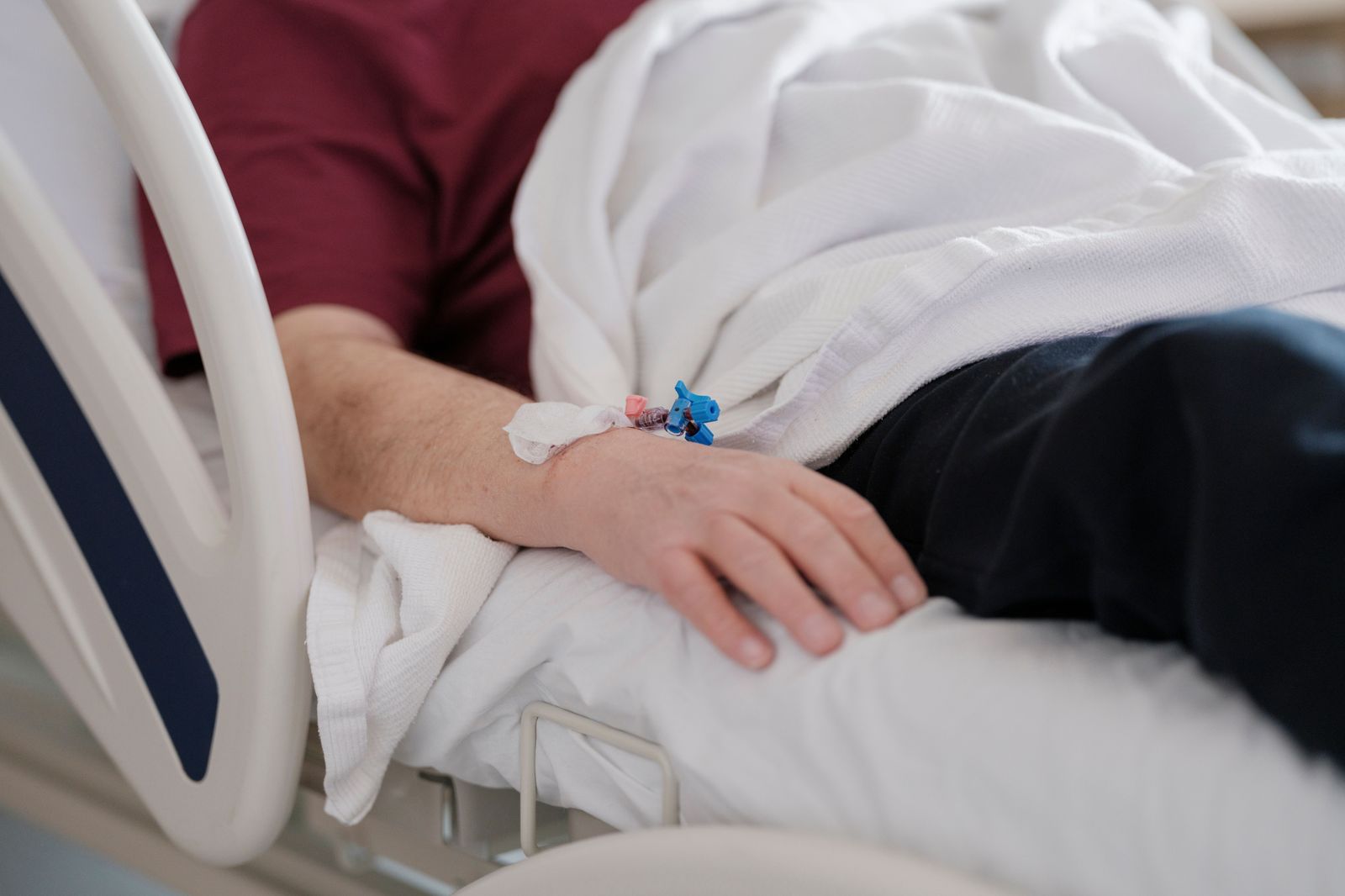 A patient resting against a pillow in the back seat on the way home from day surgery