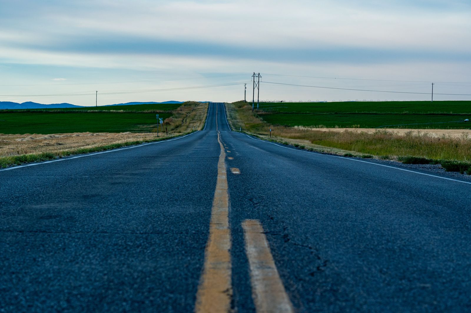 A long straight highway runs through flat farmland in southwestern Ontario