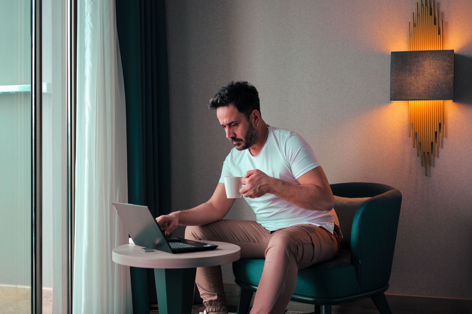 A business traveller working on a laptop in a hotel room before a meeting in downtown Hamilton