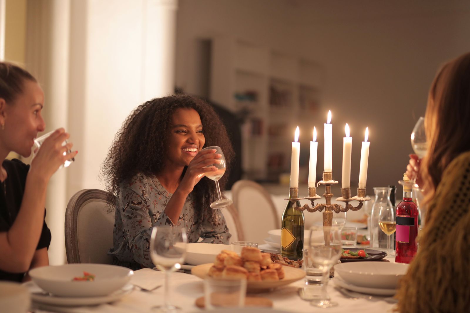 Friends sharing a candlelit dinner at a restaurant table on a Hamilton main street