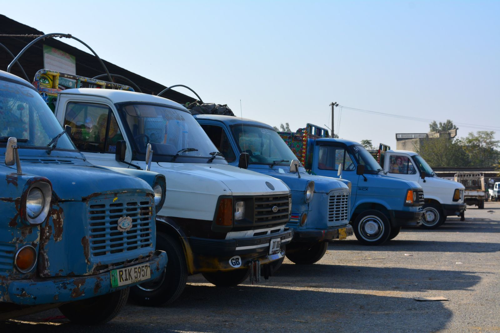 A passenger van parked near production trucks on a location
