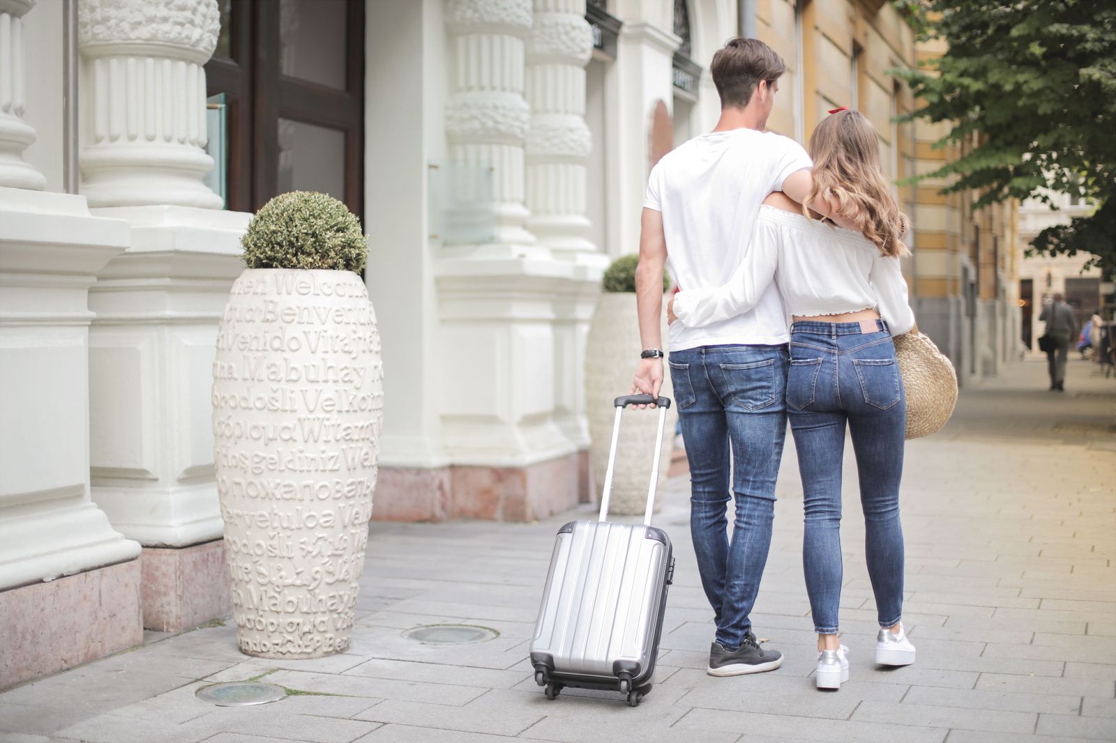A family walking through an airport terminal with suitcases and a child