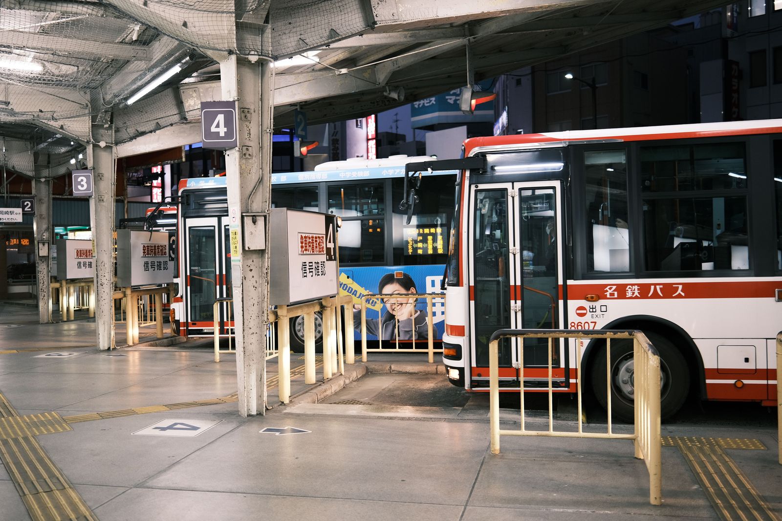 City and commuter buses lined up at a downtown bus terminal in the evening