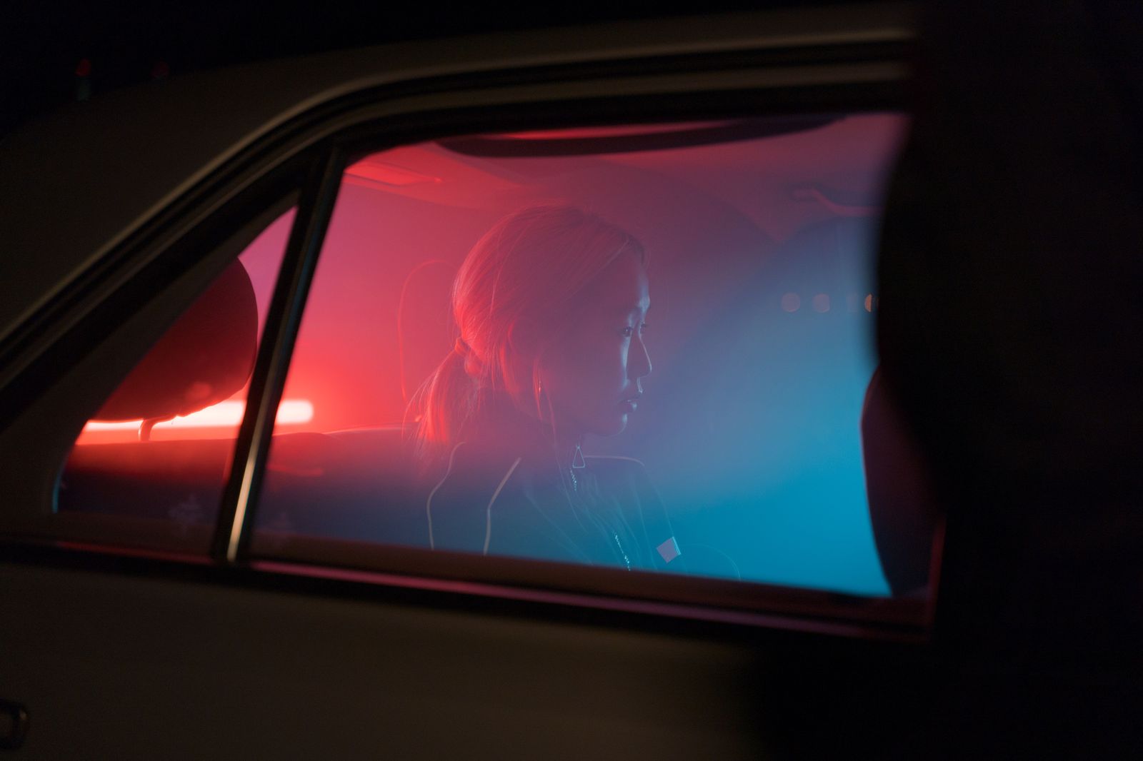Friends laughing in the back seat of a car at night after a show