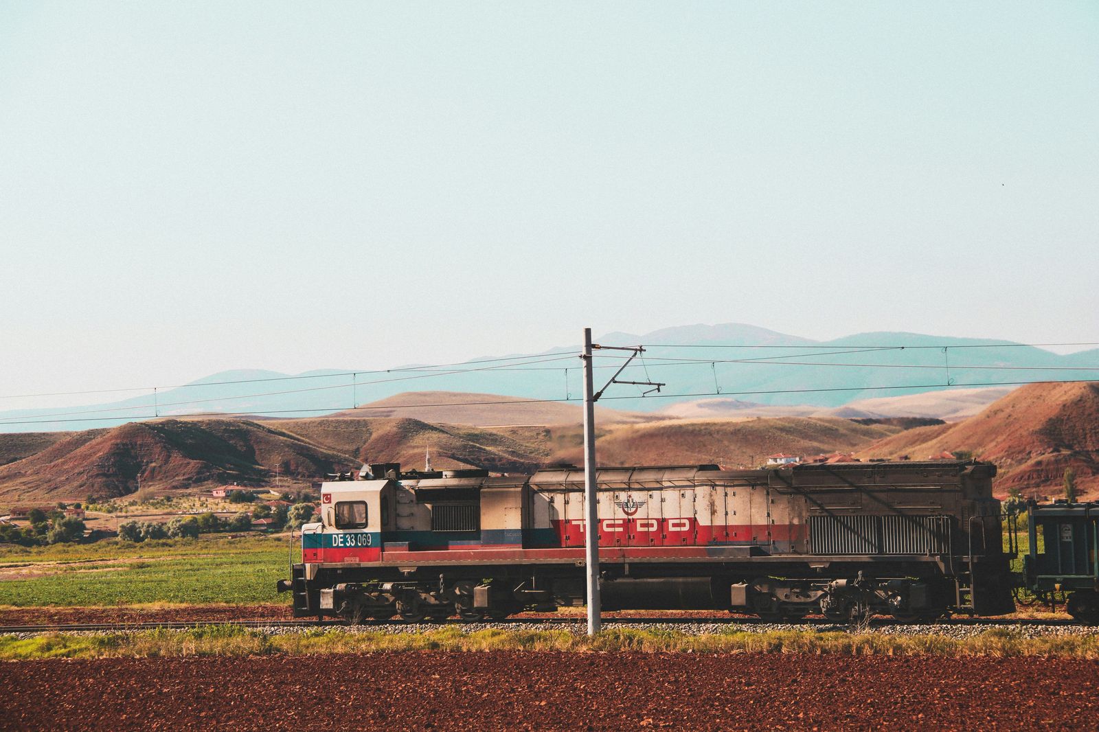 A regional train running through summer countryside