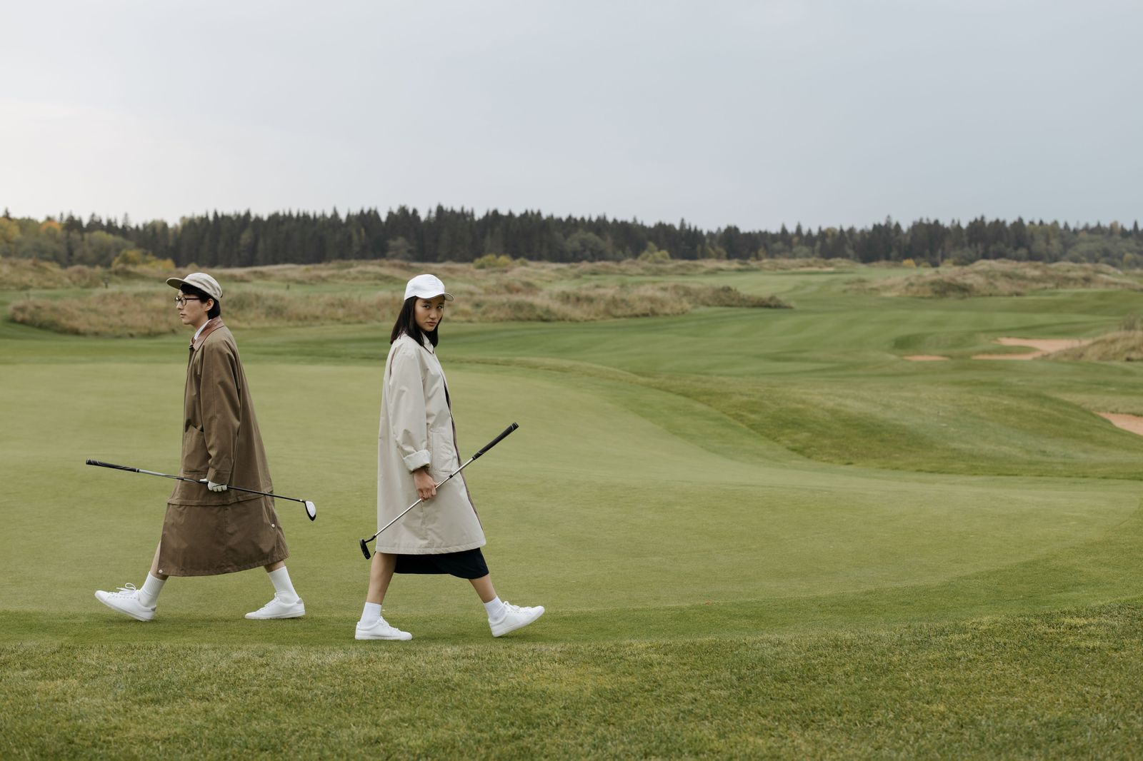 Golfers walking off a green at sunset after a round