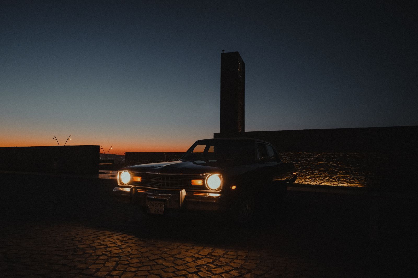 A black limousine parked outside a venue in the evening