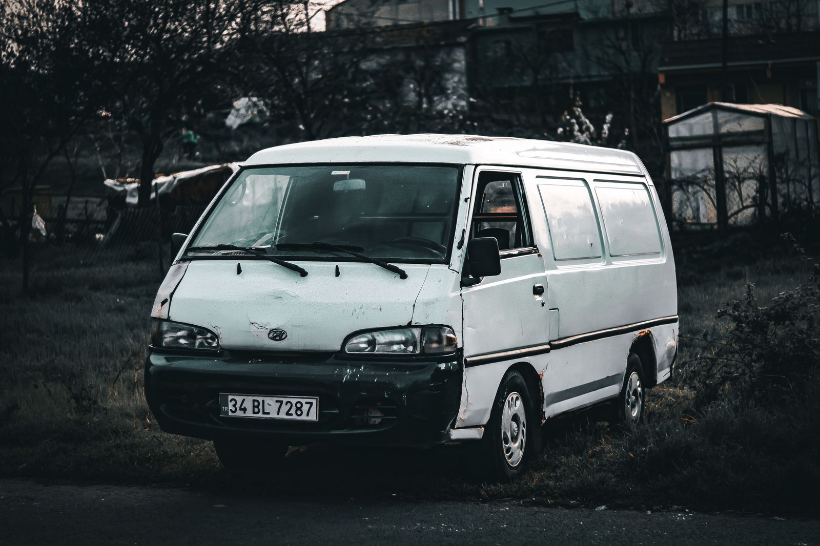 A luxury minivan with its sliding door open and luggage ready to load