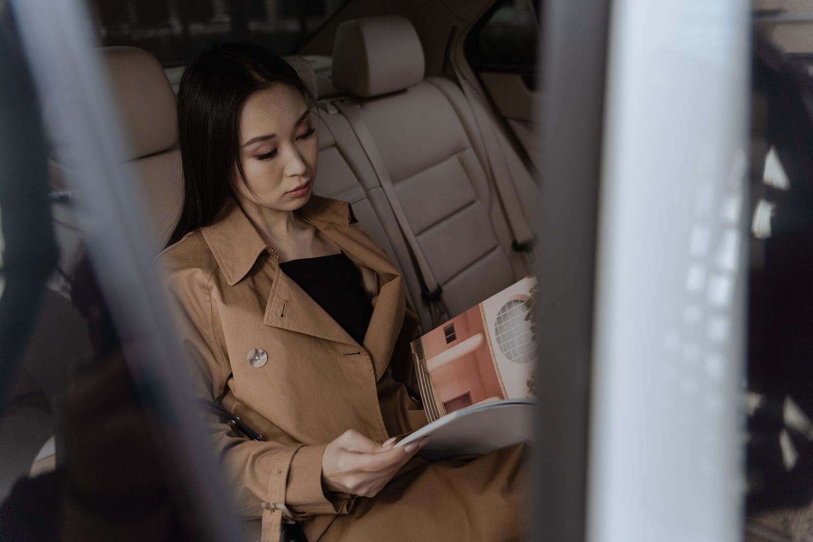 A passenger relaxing in the back seat of a chauffeured car