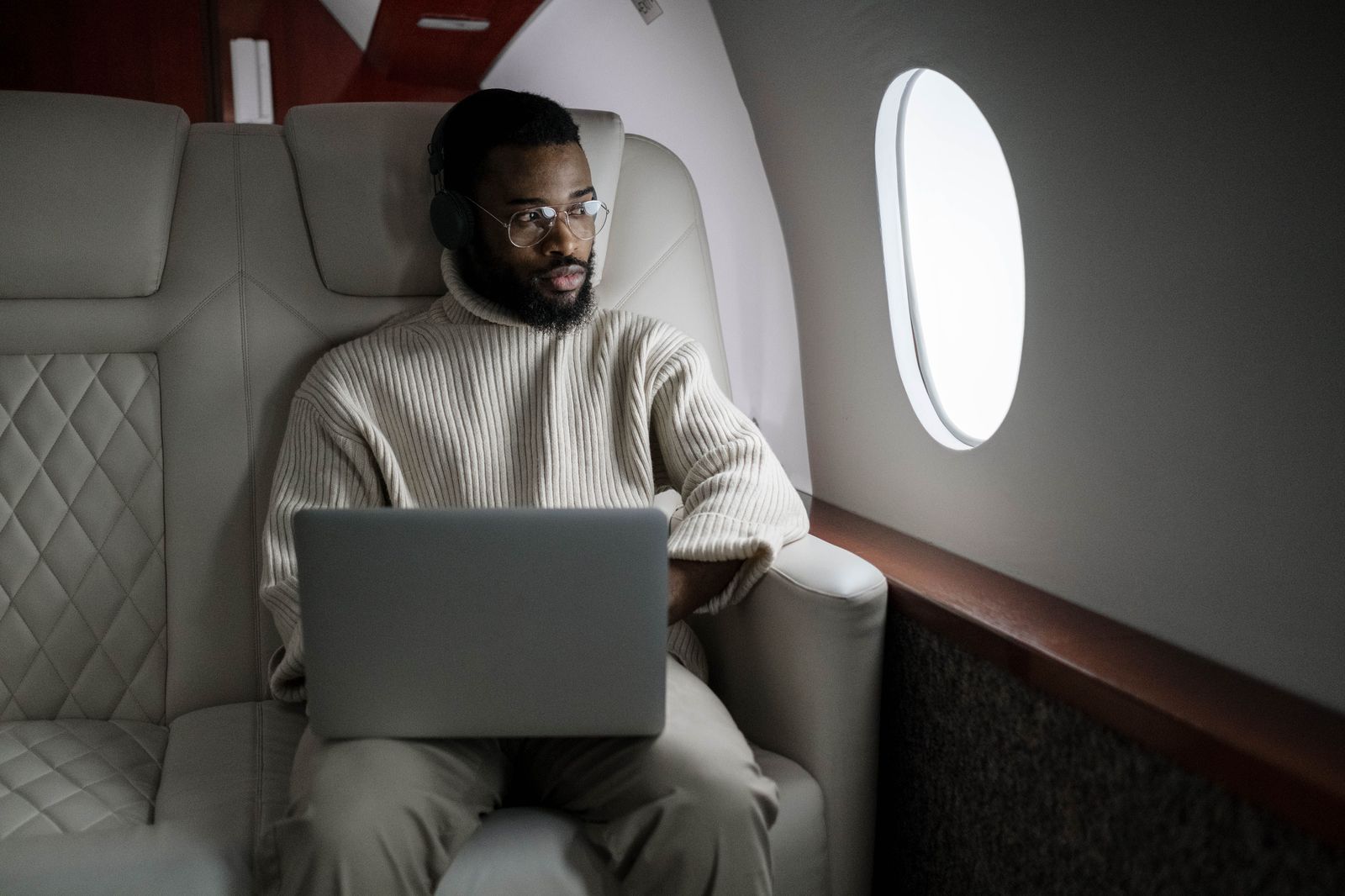A business traveller working on a laptop in the back seat of a car