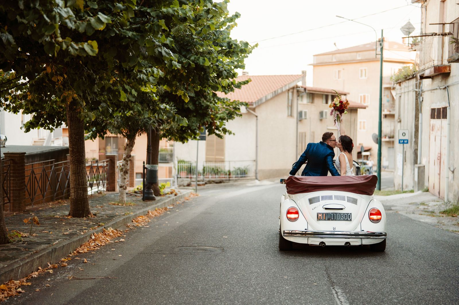 Wedding couple leaving the ceremony in a chauffeured car