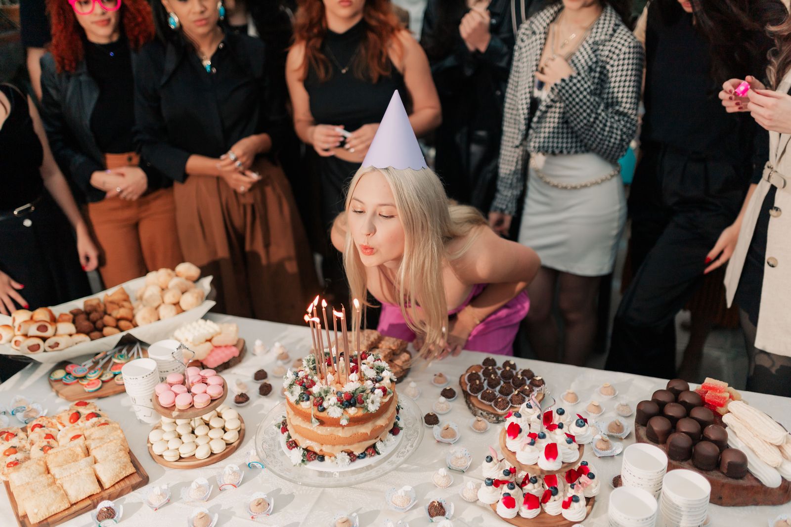 A birthday cake with candles on a restaurant table with friends