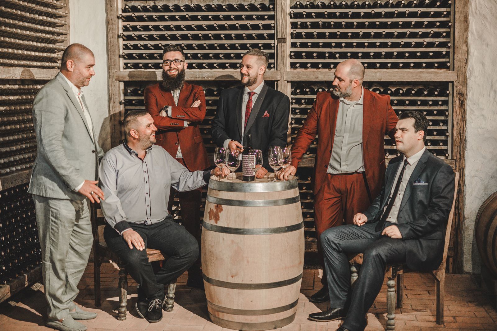 A bachelorette group sharing a wine tasting among oak barrels in Niagara