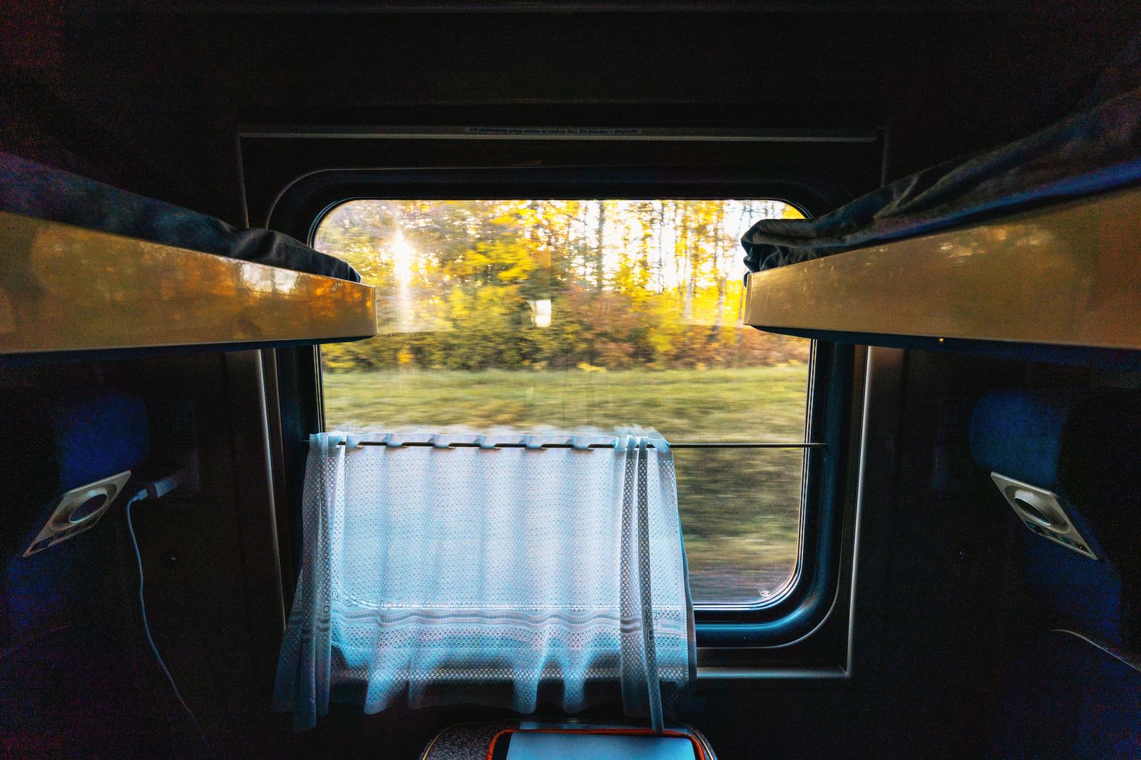 Countryside passes the window of a long-distance passenger train