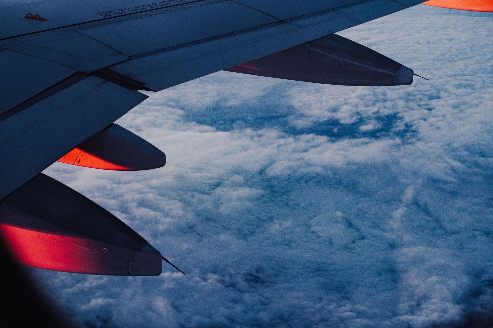 The view from an airplane window above the clouds at sunset