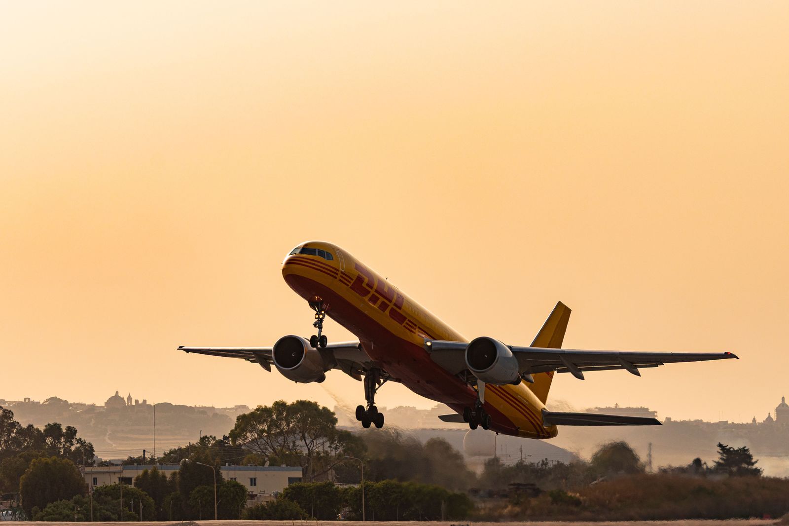 An airplane taking off from a runway at a large airport