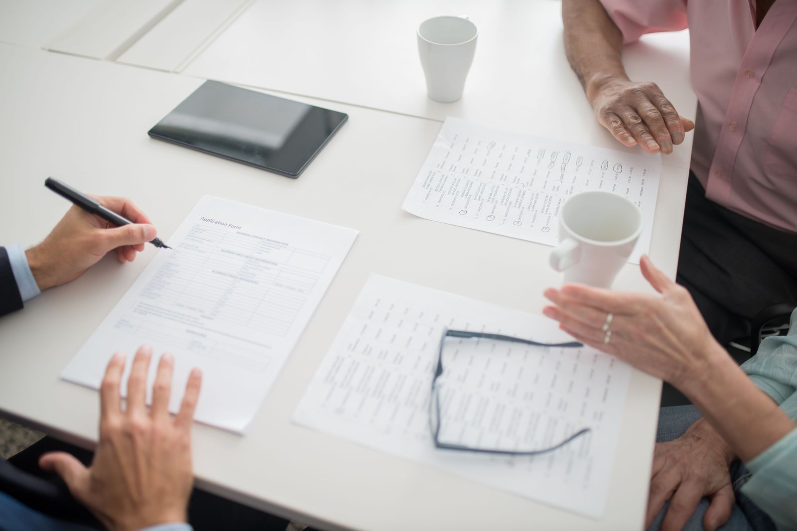 Car insurance documents and keys on a desk while checking policy details