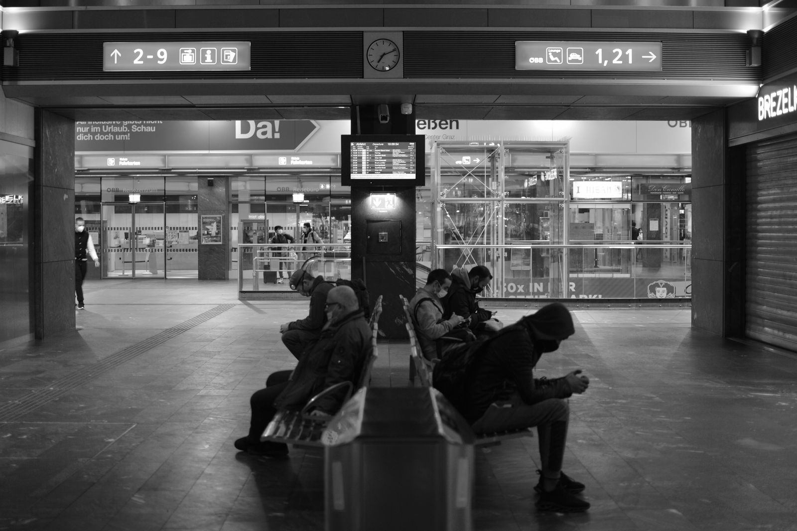 Travellers coming through an airport arrivals hall while people wait with signs