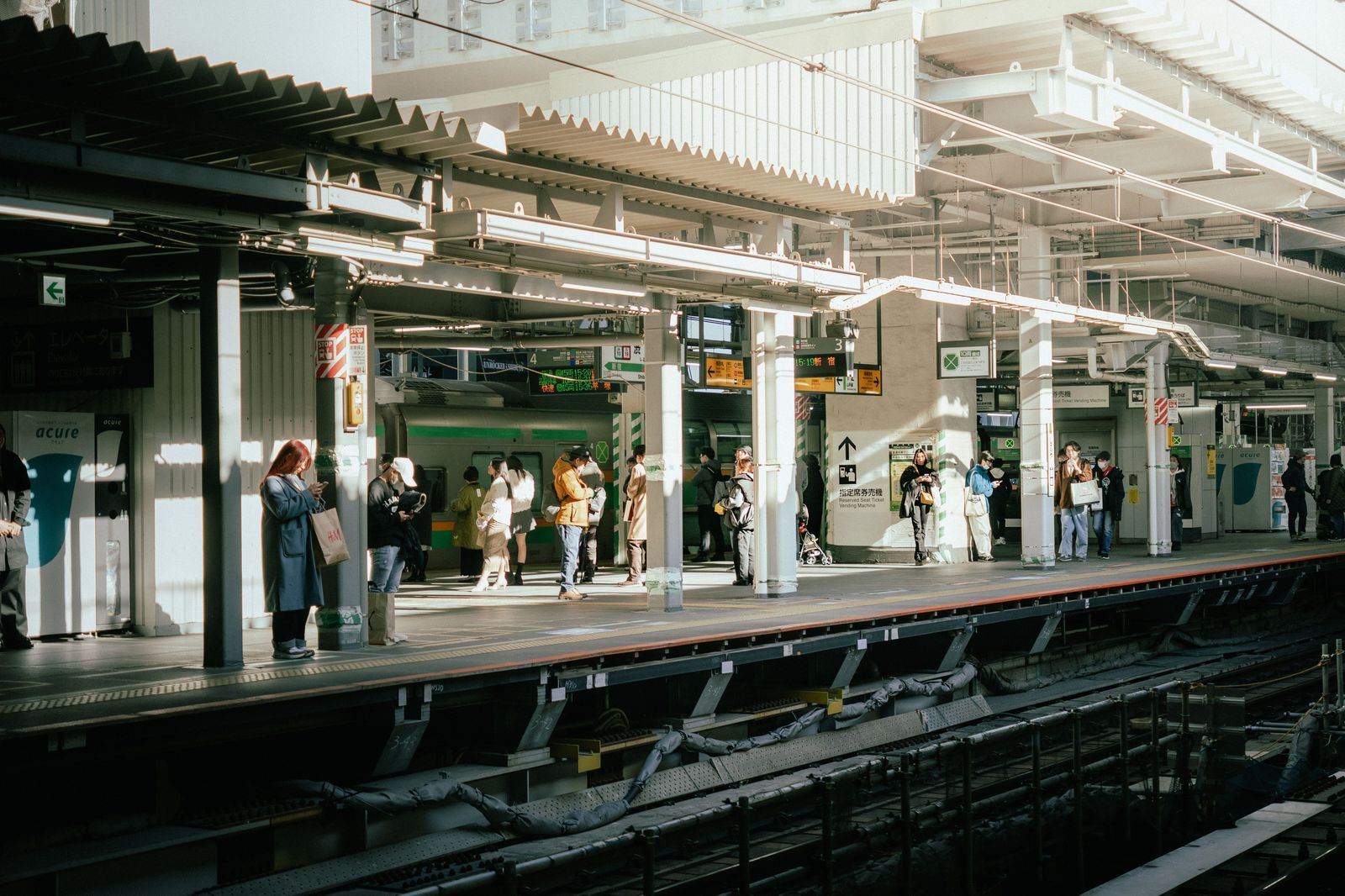 A commuter train platform early in the morning with passengers waiting