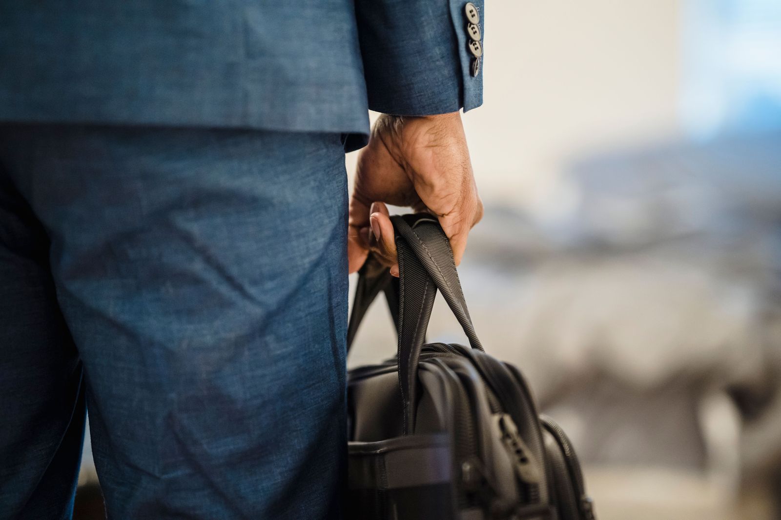 A business traveller with a small carry-on bag walking through an airport