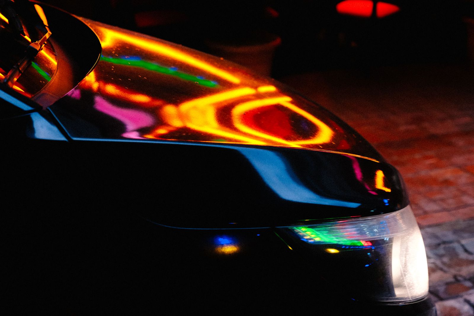 A black limousine waiting under street lights at the end of a prom night