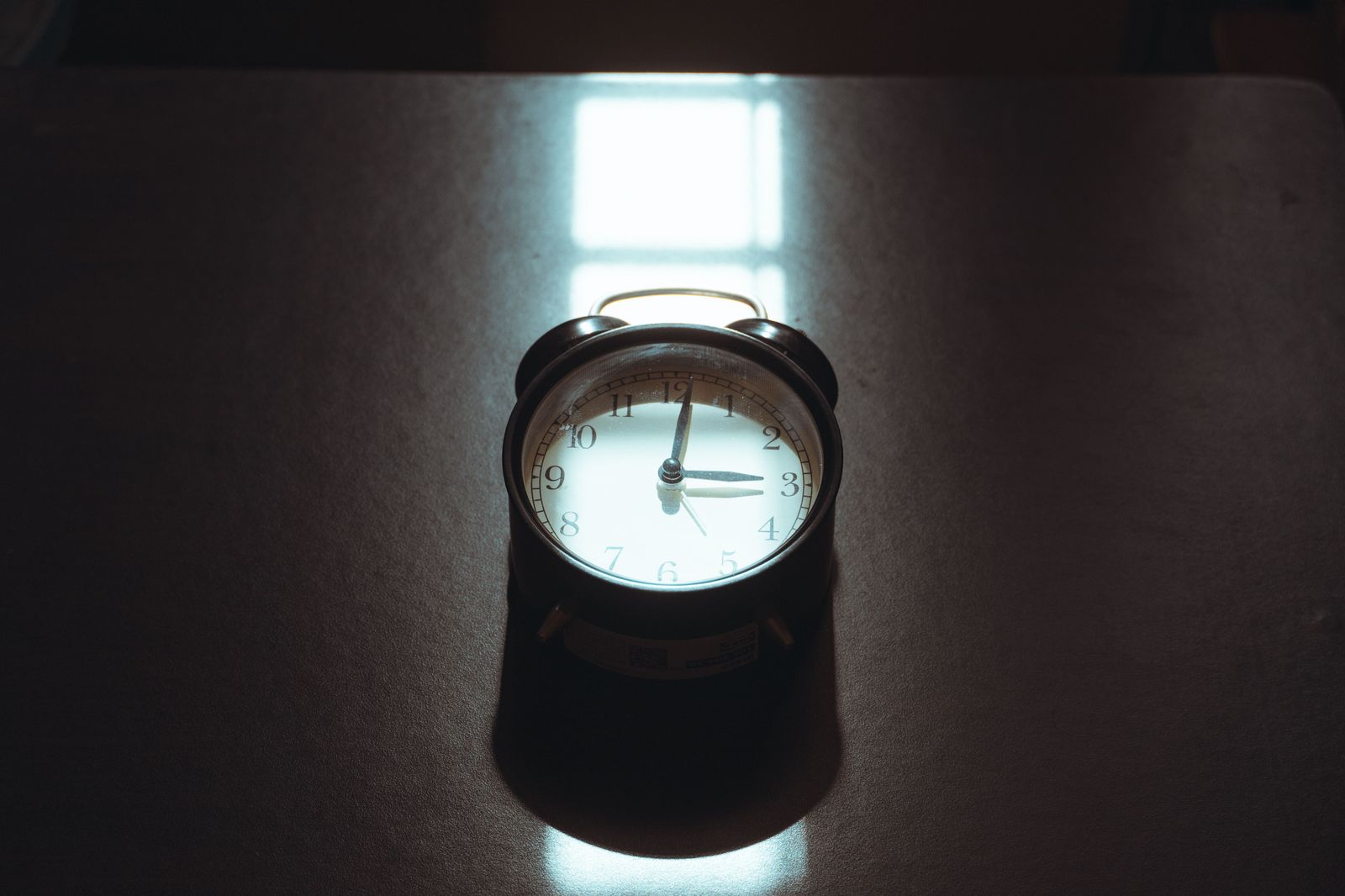 Alarm clock on a bedside table before dawn on race morning