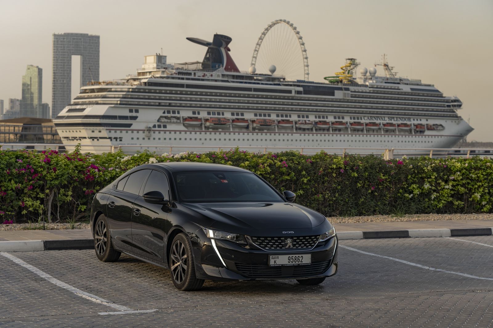 A black sedan parked outside an office tower, waiting between roadshow meetings