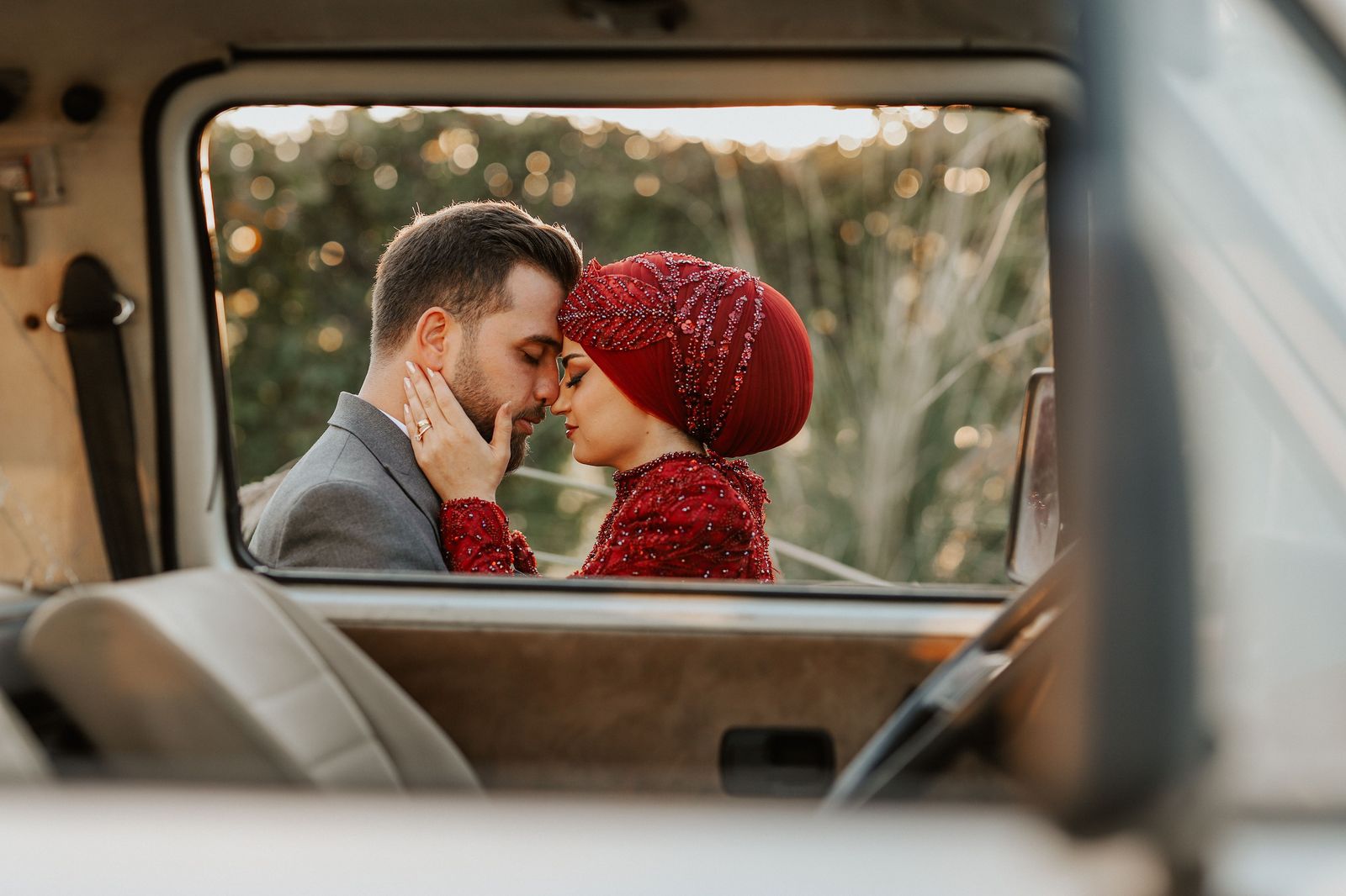 A newly married couple looking out of the rear window of their wedding car