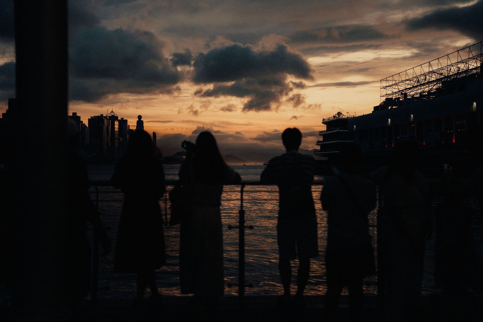 A couple watching the sunset over a harbour