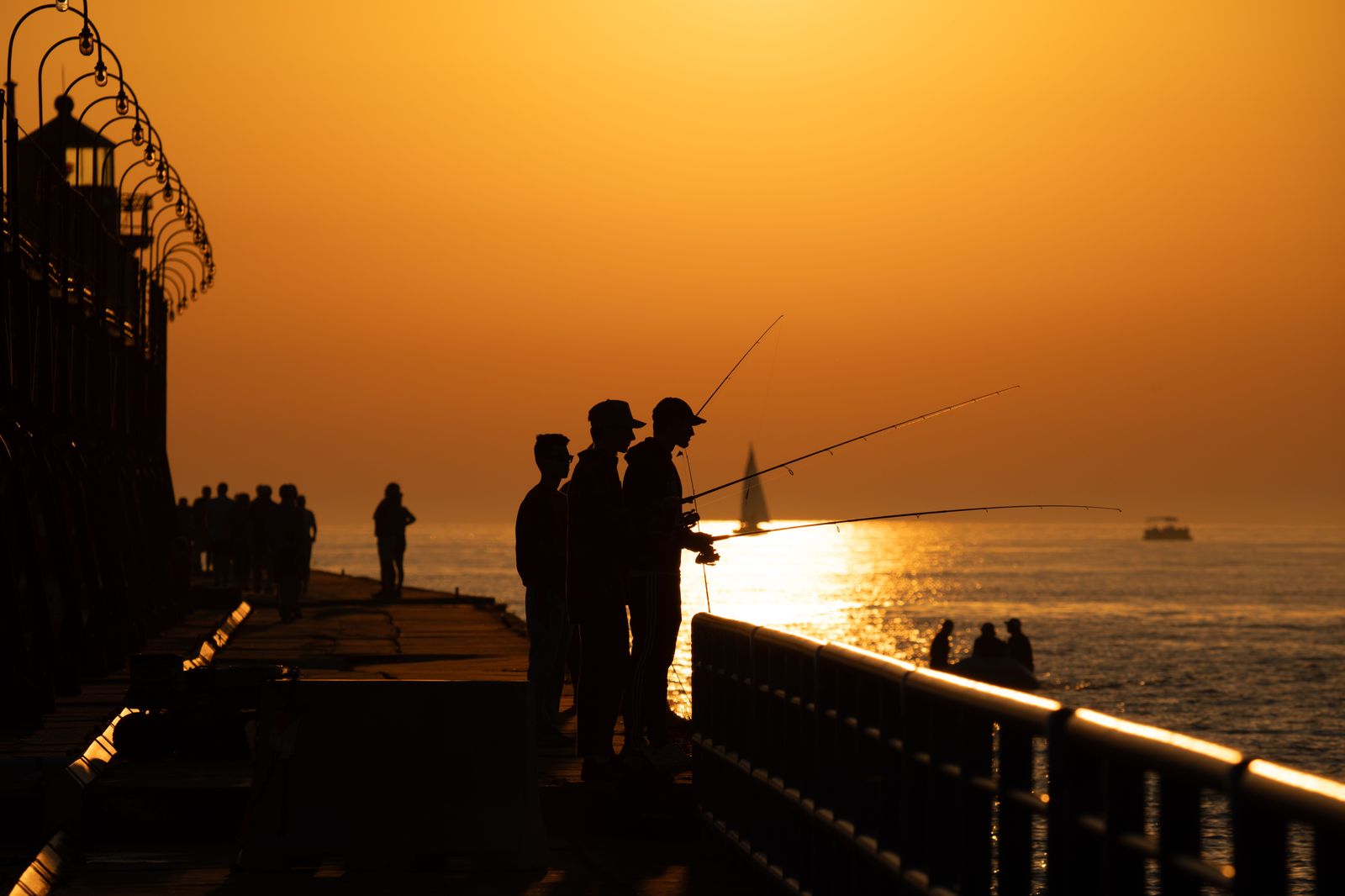 People on a lakeside pier at sunset after a waterfront festival