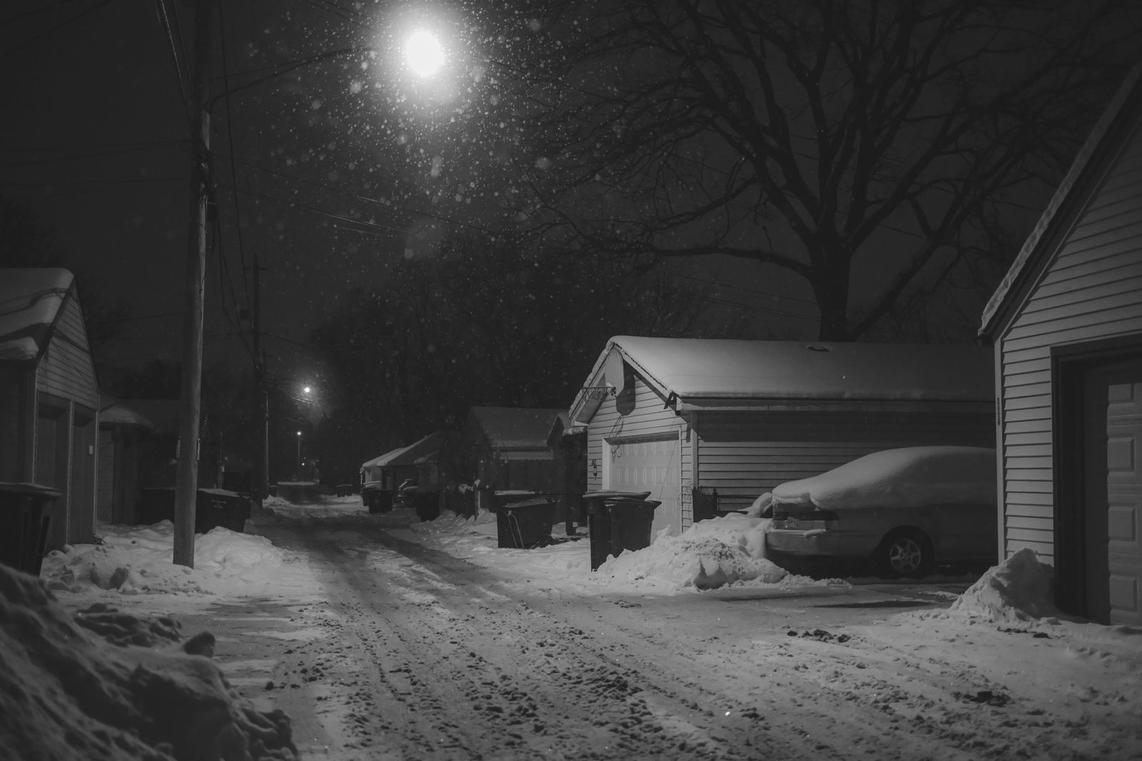 A black van on a snowy street at night, waiting to take party guests home