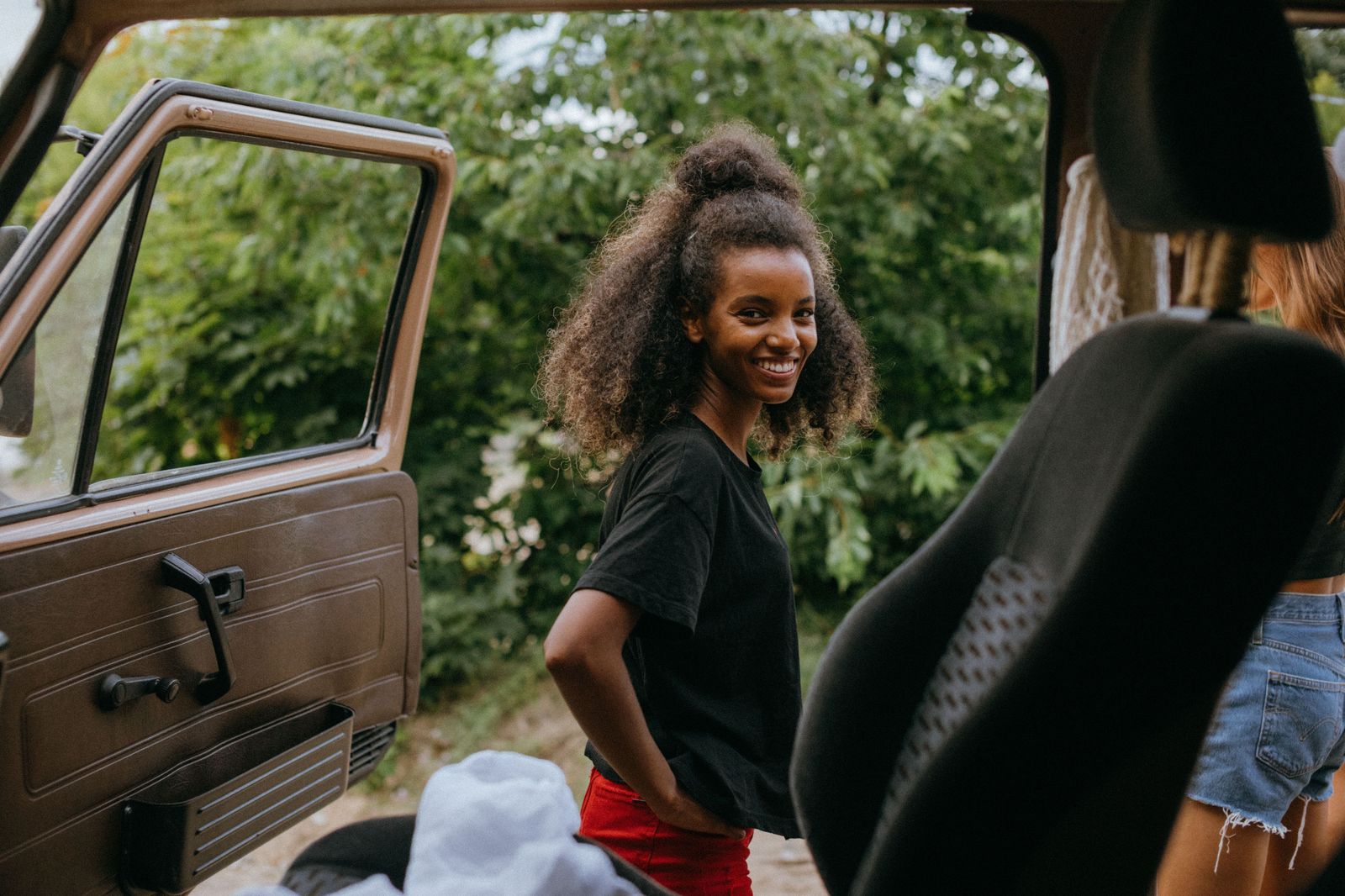 A black passenger van loading a group for a day trip