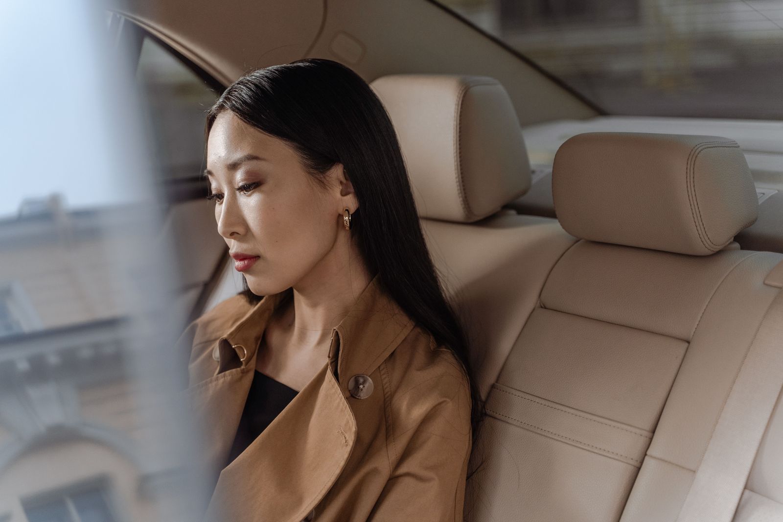Passengers relaxing in the back seat of a luxury car on a Toronto street