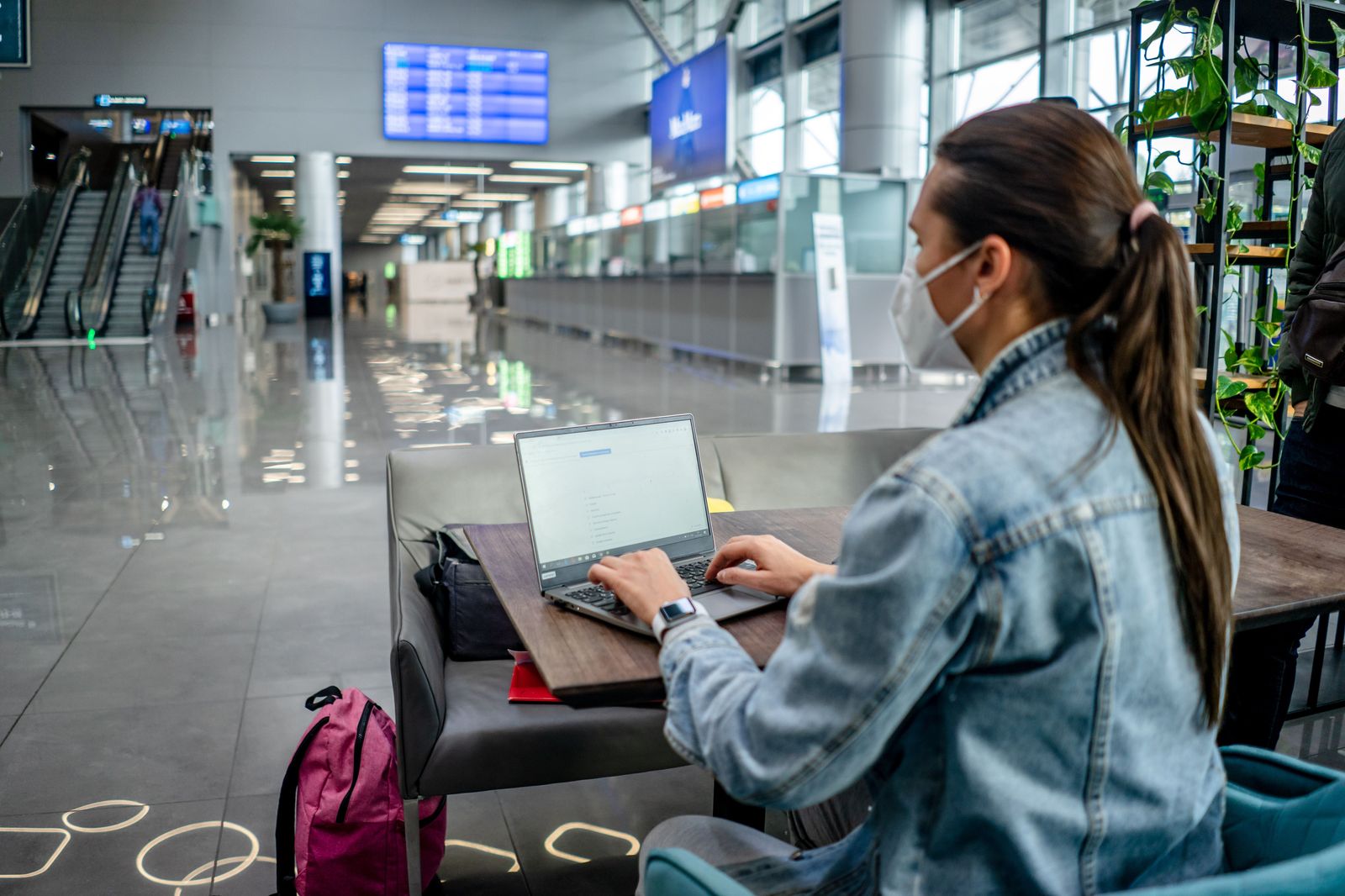 Travellers with suitcases in an airport departures hall